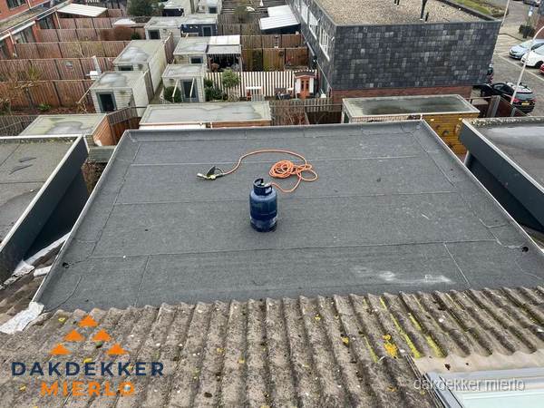 Plat dak met nieuwe bitumen dakbedekking en brandgereedschap in Mierlo