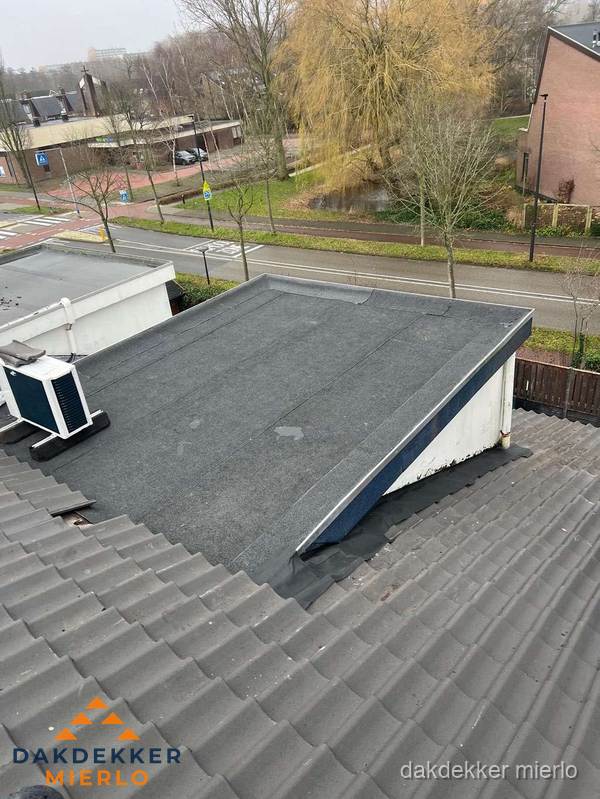 Plat dak met bitumen dakbedekking naast schuin pannendak in Mierlo Plat dak met bitumen dakbedekking naast schuin pannendak in Mierlo