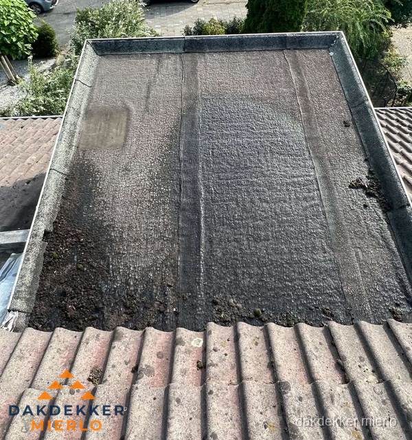Verouderd plat dak met bitumen en slijtage voor lekkage inspectie in Mierlo Verouderd plat dak met bitumen en slijtage voor lekkage inspectie in Mierlo