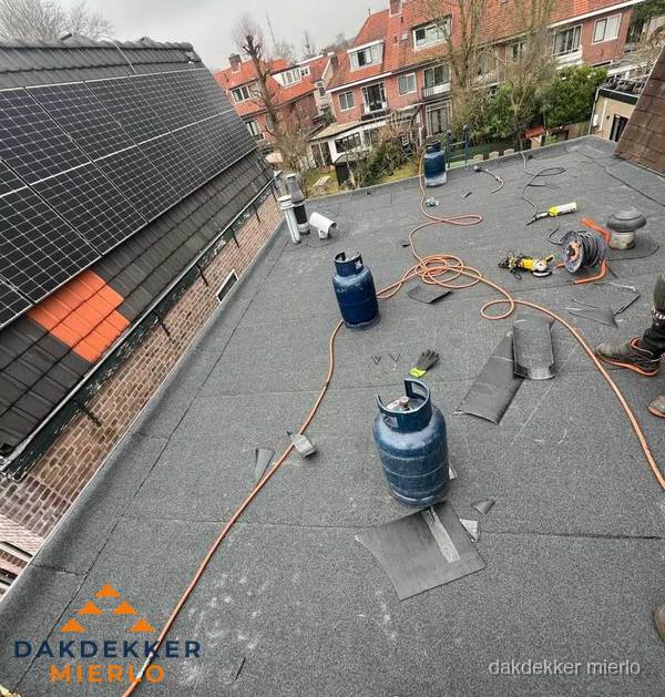 Daklekkage repareren met brandgereedschap op plat dak in Mierlo