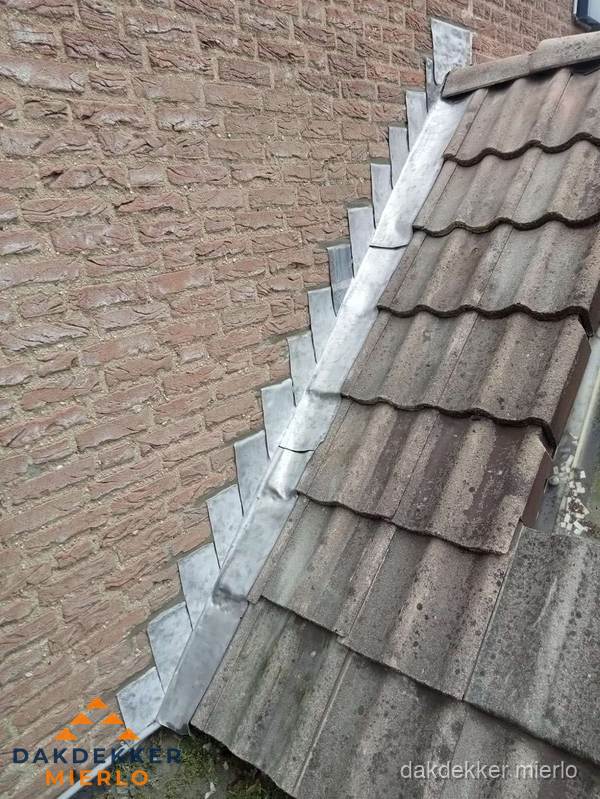 Loodslabben langs dakaansluiting bij bakstenen muur in Mierlo