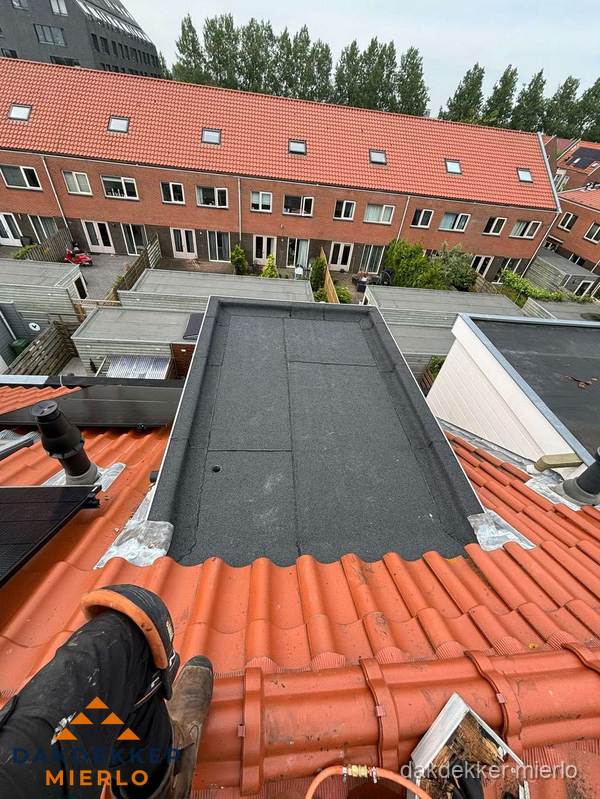Bitumen dak reparatie op plat dak tussen dakpannen in Mierlo