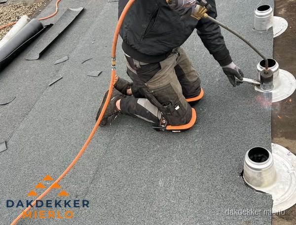 Dakdekker repareert bitumen dakleer bij dakdoorvoer in Mierlo