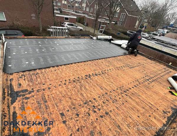 Dakdekker legt onderlaag op plat dak met houten constructie in Mierlo Dakdekker legt onderlaag op plat dak met houten constructie in Mierlo
